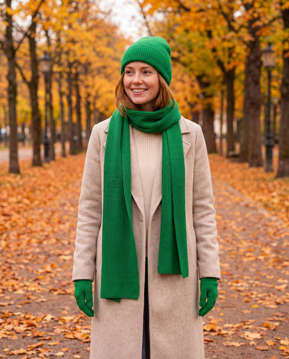 Green rib knit beanie, scarf and gloves set worn by a woman in a park