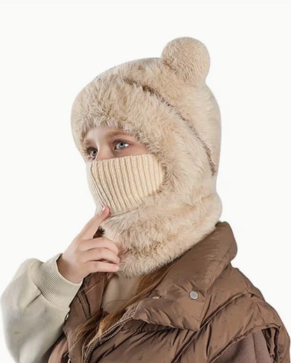 Girl wearing a beige teddy bear hood with the knit face cover pulled up