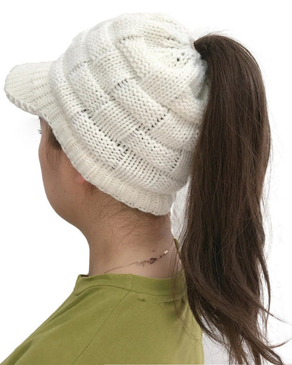 Woman wearing a white ponytail beanie with brim, ponytail through the back opening