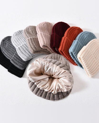 Satin-lined beanies in a row of colors, one turned to show the smooth satin lining