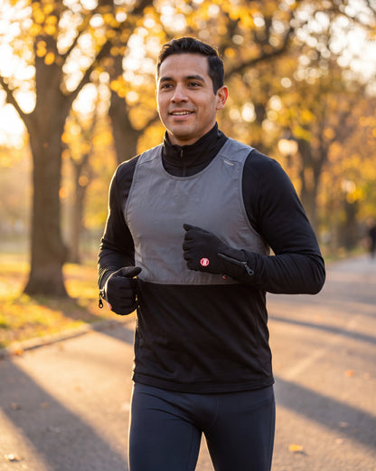 Man running in a city park at sunrise wearing black thermal touchscreen gloves